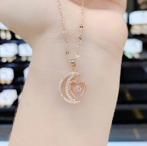 Detail of rose gold moon heart necklace with dancing stone and shimmering micro pavé crystals