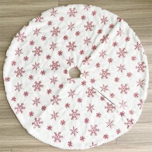 Detail der weißen Plüsch-Weihnachtsbaumdecke mit aufwendiger roter Schneeflockenbestickung