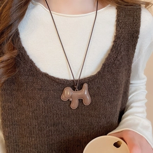 Gros plan d'un pendentif chiot marron mignon sur un collier en cordon tressé de style