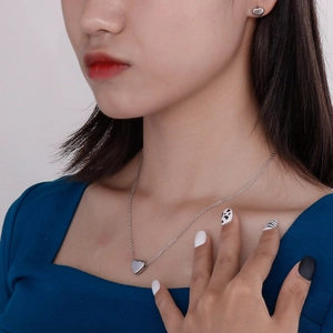 Set collana con pendente a cuore e orecchini a lobo in argento indossati da una modella