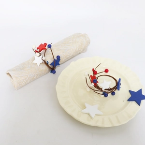 Close-up of patriotic red white and blue star napkin rings with berry accents on a table