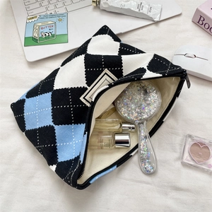 Close-up of checkered canvas makeup bag showing spacious interior with cosmetic items