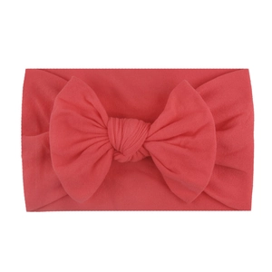 Soft nylon infant headband featuring a large coral red double-layer knit bow