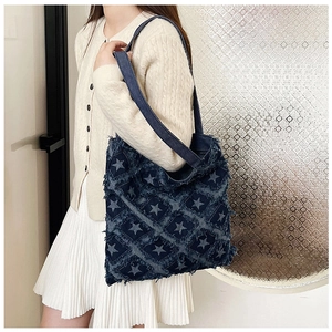 Detail of vintage star pattern denim tote bag showing frayed edges and large capacity