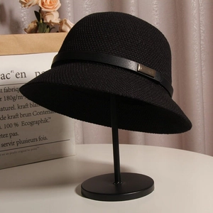 Détail d'un chapeau de soleil noir tissé avec bride en cuir sur support d'exposition