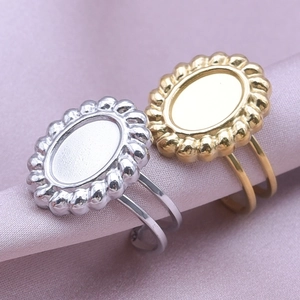 Detail of oval beaded gold and silver stainless steel rings on purple silk fabric
