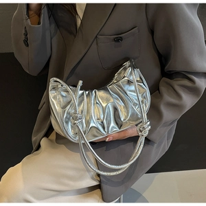 Fashionable metallic silver pleated cloud bag worn by model with high gloss finish