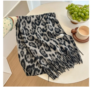 Detail shot of black and white leopard print cashmere scarf with tassel and material label