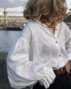 Detail of white linen shirt with elegant lantern sleeves and ruffled cuffs in outdoor setting