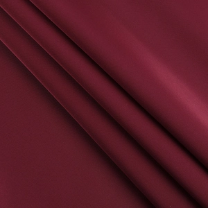 Detail of high-quality burgundy evening dress fabric showing texture and smooth drape