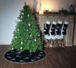 Detail of black knitted Christmas tree skirt featuring white snowflake and candy cane patterns