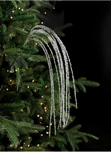 Detailopname van sprankelende zilveren glittertakken op een verlichte kerstboomtak