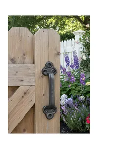 Detail of vintage cast iron handle with hammer texture on a light wood garden gate