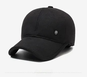 Detail of winter baseball cap with ear flaps featuring a metal M logo and wool texture