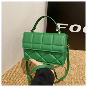 Detail of lime green quilted leather handbag with gold hardware and adjustable strap