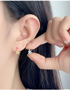 Detail of leaf-shaped S925 silver clip-on earrings with white zircon in gold and silver