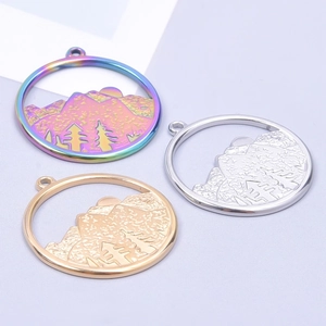 Three circular hollow mountain pendants in rainbow, silver and gold finishes on purple card