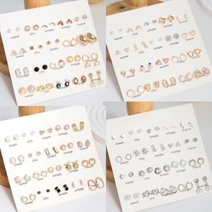 Detail view of various Christmas earrings with colorful charms on card display