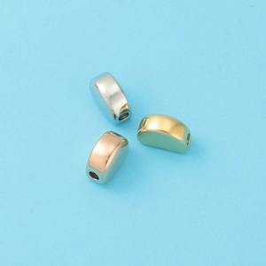 Close-up of DIY metal spacer beads in silver, gold, and rose gold on blue background