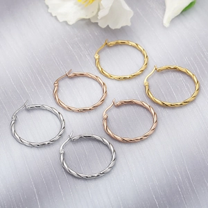 Three pairs of twisted spiral hoop earrings in silver, gold and rose gold finishes