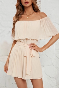 Detail of off-shoulder pleated romper in apricot with waist tie and textured chiffon fabric