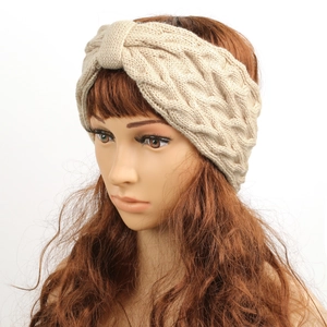 Macro view of oatmeal cable knit headband showing thick texture and twisted bow design