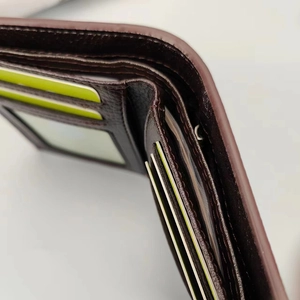 Detalle del interior de la cartera de cuero marrón con ranuras para tarjetas y costuras