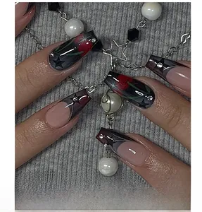 Macro detail of dark gothic press-on nails with black stars, red flowers, and silver rhinestones