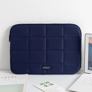 Detail of dark blue quilted laptop sleeve with minimalist grid stitching and logo