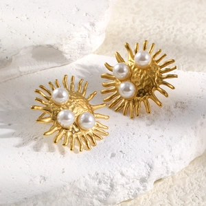 Vintage 18K gold plated sunburst stud earrings with three white faux pearls on stone background