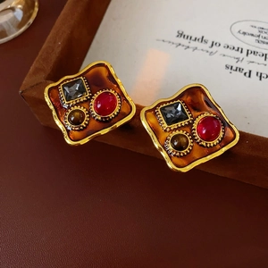 Boucles d'oreilles vintage en émail ambré avec gemmes colorées sur fond de cuir