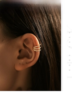 Macro view of triple-layered gold ear cuff with pave set cubic zirconia stones