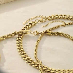 Close-up of 18K gold plated Cuban, twist, and bead chain layered necklaces with lobster clasp