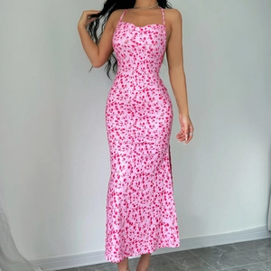 Detail view of pink floral halter dress featuring a stylish side slit and light fabric