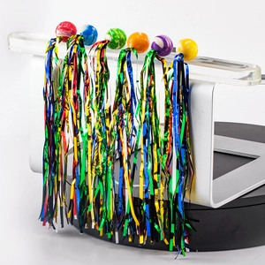 Colorful elastic bouncy balls with metallic tinsel fringes hanging on a display rack