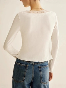 Back view of a white ribbed long sleeve tee with delicate lace trim and v-neck design
