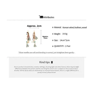 Detail view of bohemian drop earrings with brown feathers, teal tassels and wood beads