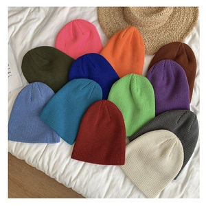 Winter knit beanies displayed in various vibrant colors on a textured white background