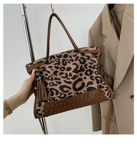 Detail of leopard print handbag featuring brown leather tassels and studded bottom base
