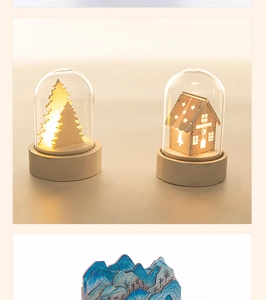 Warm glow from glowing wooden Christmas house and tree inside glass cloche light decoration
