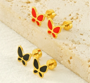 Macro shot of gold butterfly ear studs with red and black enamel and screw back design
