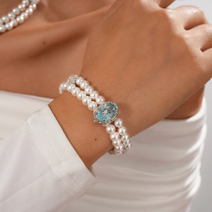 Double-layer pearl bracelet with a large oval blue gemstone and zircon star accents