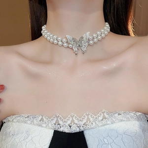 Close-up of double-layered pearl necklace with hollow butterfly pendant on model