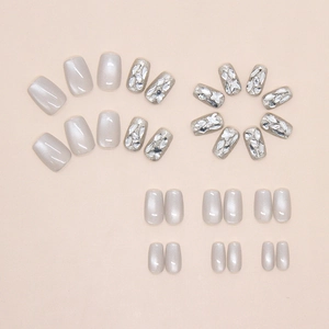 Flat lay of shimmering silver-grey cat-eye press-on nails with 3D rhinestones