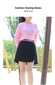 Detail of high-waisted black A-line skirt with side slit and decorative brown belt