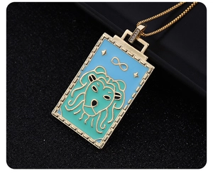 Macro shot of gold tarot pendant with blue enamel lion head and infinity symbol