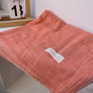 Detail of thin orange cotton linen scarf with tassels and Autumn On Line label