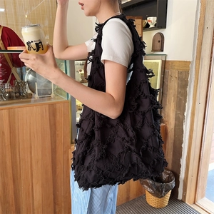 Detail of black canvas tote bag showing fringe texture and large capacity design