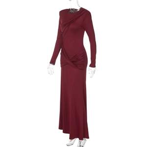 Dettaglio dell'abito lungo bordeaux con eleganti pieghe asimmetriche e drappeggio laterale