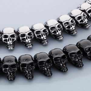 Polished skull cast steel bracelets in silver and gun-black finishes in a macro view